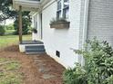 View of front door with planter boxes, stone walkway, gray steps and dark wooden posts at 13131 601 S Hwy, Midland, NC 28107