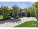 Spacious three car garage with a large driveway and mature landscaping at 15909 Heath Aster Way, Davidson, NC 28036