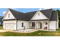 Lovely two-story house with white siding, a welcoming porch swing, and a manicured lawn, creating a cozy and inviting atmosphere at 2119 Smith Rd, Clover, SC 29710
