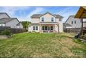 Expansive backyard with lush green grass, a wooden fence, and a covered patio perfect for outdoor entertaining at 235 Whispering Hills Dr, Locust, NC 28097
