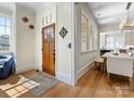 Bright foyer with hardwood floors, wooden door, and view to kitchen, flowing into a dining space with stylish decor at 2500 Marshall Pl, Charlotte, NC 28203