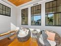 Cozy covered porch featuring comfortable wicker seating, wood floors, and well lit by natural light through large windows at 2500 Marshall Pl, Charlotte, NC 28203