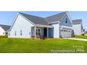 Lovely blue one-story home features a welcoming porch and a two-car garage with lush green lawn at 355 Gray Wolf St # 122P, China Grove, NC 28023