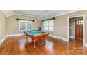 Spacious game room with hardwood floors, billiard table, and ample natural light at 4467 Woodlark Ln, Charlotte, NC 28211