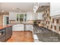 Modern kitchen with stainless steel appliances, white cabinets, and large windows at 4467 Woodlark Ln, Charlotte, NC 28211