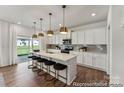 Modern kitchen featuring a large island with seating, stylish pendant lighting, and stainless steel appliances at 510 Black Bear St # 145P, China Grove, NC 28023