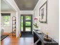 Stylish entryway with modern door, sleek console table, and hardwood floors at 5218 Addison Dr, Charlotte, NC 28211
