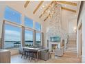 Spacious living room with a stone fireplace, high ceilings, and waterfront views at 7679 Rabbit Cir, Denver, NC 28037