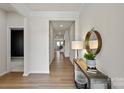 Light-filled hallway with neutral paint, white trim, wood flooring, and an elegant console table at 8000 Millbridge Pkwy, Waxhaw, NC 28173