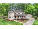 Traditional home boasts manicured lawn, mature trees, attached two car garage and inviting front porch at 8214 Coristar Pl, Huntersville, NC 28078