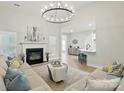 Bright, open-concept living room with a cozy fireplace, modern chandelier, and seamless flow to the kitchen at 8726 Castle Cliff Dr, Matthews, NC 28105