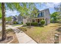A charming two-story home with stone accents and a well-maintained lawn on a sunny day at 9527 Turning Wheel Dr, Charlotte, NC 28214
