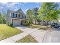 A well-manicured lawn leads to a two-story home with an attached garage and lengthy driveway at 9527 Turning Wheel Dr, Charlotte, NC 28214