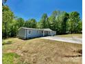 Charming light blue house with a concrete driveway and a well-maintained lawn at 109 Bee Tree Ln, Salisbury, NC 28144