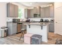 Modern kitchen featuring gray cabinets, granite countertops, stainless steel appliances, and a center island at 11010 Redcoat Hill Ln # 33, Huntersville, NC 28078