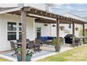 Charming patio with pergola, dining set, plush outdoor seating, grill, and bar, perfect for relaxing and entertaining at 1218 Juddson Dr, Waxhaw, NC 28173