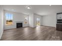 Bright living room features wood floors, a fireplace, and windows offering views of the outdoors at 124 Canary Ln # 7, Mooresville, NC 28115