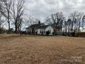Exterior view of the home and yard showcasing mature trees at 14131 Lucia Riverbend Hwy, Mount Holly, NC 28120