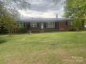 Charming one-story brick home featuring a well-manicured front lawn and mature trees at 1620 Moss Springs Rd, Albemarle, NC 28001