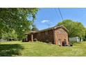 Brick home with a spacious yard, mature trees, and a storage shed at 1684 Montevista Dr, Shelby, NC 28150