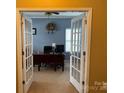 Home office featuring French doors, neutral carpet, and a ceiling fan at 1905 Yellow Daisy Dr, Matthews, NC 28104