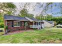 Traditional brick house with a well-kept lawn, mature trees, and a detached garage for ample parking at 221 Delview Dr, Cherryville, NC 28021
