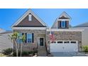 Up close, this charming brick home features a two-car garage, inviting entryway, and patriotic American flag at 2333 Talon Point Cir, Fort Mill, SC 29715