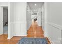 Inviting hallway featuring pristine white walls with elegant wainscoting and beautiful hardwood flooring at 2333 Talon Point Cir, Fort Mill, SC 29715