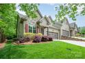 Close-up of the home's facade, highlighting the stone detailing, landscaping, and well-maintained lawn at 3004 Village Ridge Dr, Gastonia, NC 28056