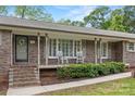 Close-up of a cozy front porch with rocking chairs and a charming brick facade at 3378 Tanglewood Dr, Rock Hill, SC 29732