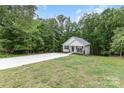 Charming home featuring a well-manicured lawn, long concrete driveway, and inviting front porch in a wooded setting at 409 Woodcrest Ln, Albemarle, NC 28001
