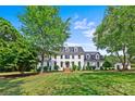 Beautiful white home with well-manicured lawn and surrounded by mature trees on a sunny day at 426 Walden Trl, Waxhaw, NC 28173