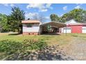 Property featuring multiple outbuildings including a metal carport and a red barn at 4734 Polk Ford Rd, Stanfield, NC 28163
