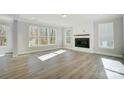 Bright living room with a modern fireplace, large windows, and wood floors at 5027 Mclaughlin Loop # 61, Waxhaw, NC 28173