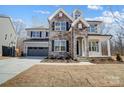 Charming two-story home with a stone facade and light gray siding, with an attached two-car garage at 5031 Mclaughlin Loop # 60, Waxhaw, NC 28173