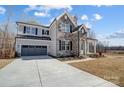 Handsome two-story home featuring a stone facade, neutral siding, dark shutters, and an attached two-car garage at 5031 Mclaughlin Loop # 60, Waxhaw, NC 28173