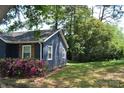 Charming blue home featuring wooden shutters and vibrant pink azaleas at 510 Belmont Mount Holly Rd, Belmont, NC 28012