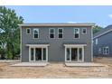 Townhome featuring a gray exterior, multiple windows, sliding glass doors, and a concrete patio at 511 Bowman Rd, Charlotte, NC 28217
