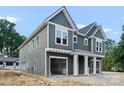 Two-story home featuring gray siding, white trim, a two-car garage, and a covered entryway at 511 Bowman Rd, Charlotte, NC 28217
