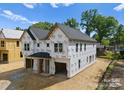An exterior side view of a new construction duplex featuring Tyvek wrap, and attached garages at 511 Bowman Rd, Charlotte, NC 28217