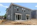 Rear view of a new townhome featuring a gray exterior, sliding glass doors, and a concrete patio at 511 Bowman Rd, Charlotte, NC 28217