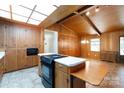 Kitchen with wood-paneled walls and cabinets, island cooktop, and skylight providing ample natural light at 567 Willie Ln, York, SC 29745