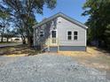 A gray-sided single-Gathering home with a new wooden front porch and gravel yard at 589 Fork Rd, Norwood, NC 28128