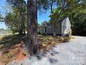 Gray-sided single-Gathering home with new gravel driveway and mature trees at 589 Fork Rd, Norwood, NC 28128