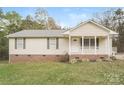 Inviting single-story house with a cozy front porch, brick foundation, and a well-kept lawn at 592 Rambo E Rd, Rock Hill, SC 29730