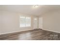 Bright living room features neutral paint, hardwood floors, a large window, and a front entry door at 592 Rambo E Rd, Rock Hill, SC 29730