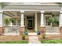 Charming front porch featuring a ceiling fan, potted plants, and comfortable seating area with a welcoming ambiance at 1000 Millbank Dr, Matthews, NC 28104