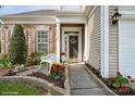 Inviting entrance with stone accents, decorative shutters, bench, and lovely landscaping at 10314 Threatt Woods Dr, Charlotte, NC 28277
