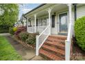 Inviting front porch with brick steps and white railing, perfect for relaxing and enjoying the outdoors at 106 S Oakwood Dr, Kings Mountain, NC 28086