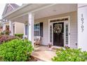 Charming front entrance with a decorative wreath, rocking chairs, and manicured bushes at 10707 Charmont Pl, Huntersville, NC 28078
